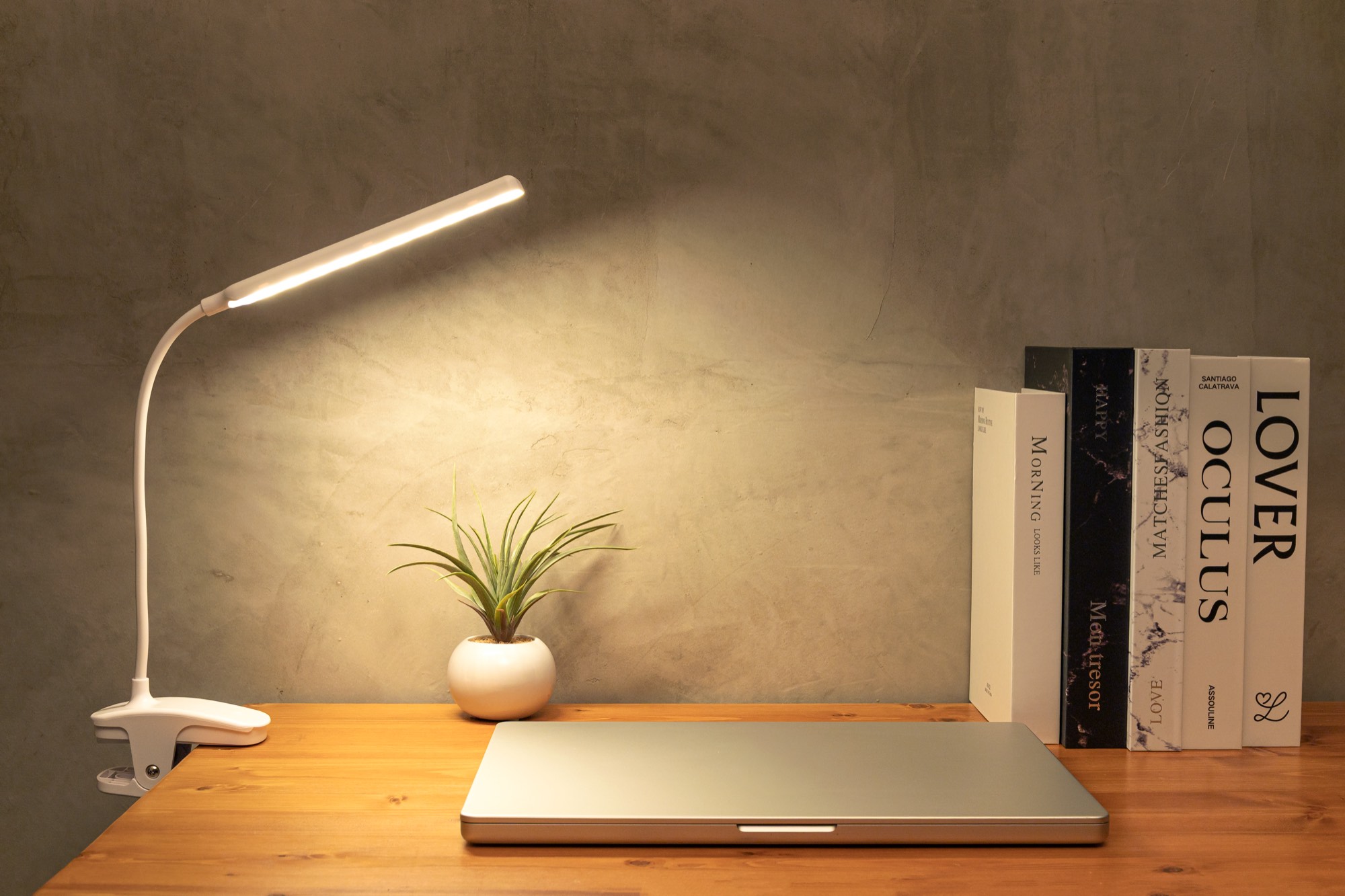 デスクの天板に挟んだLUVIAL Smart Clip Lightが、ノートパソコンの手元をあたたかく照らしている様子